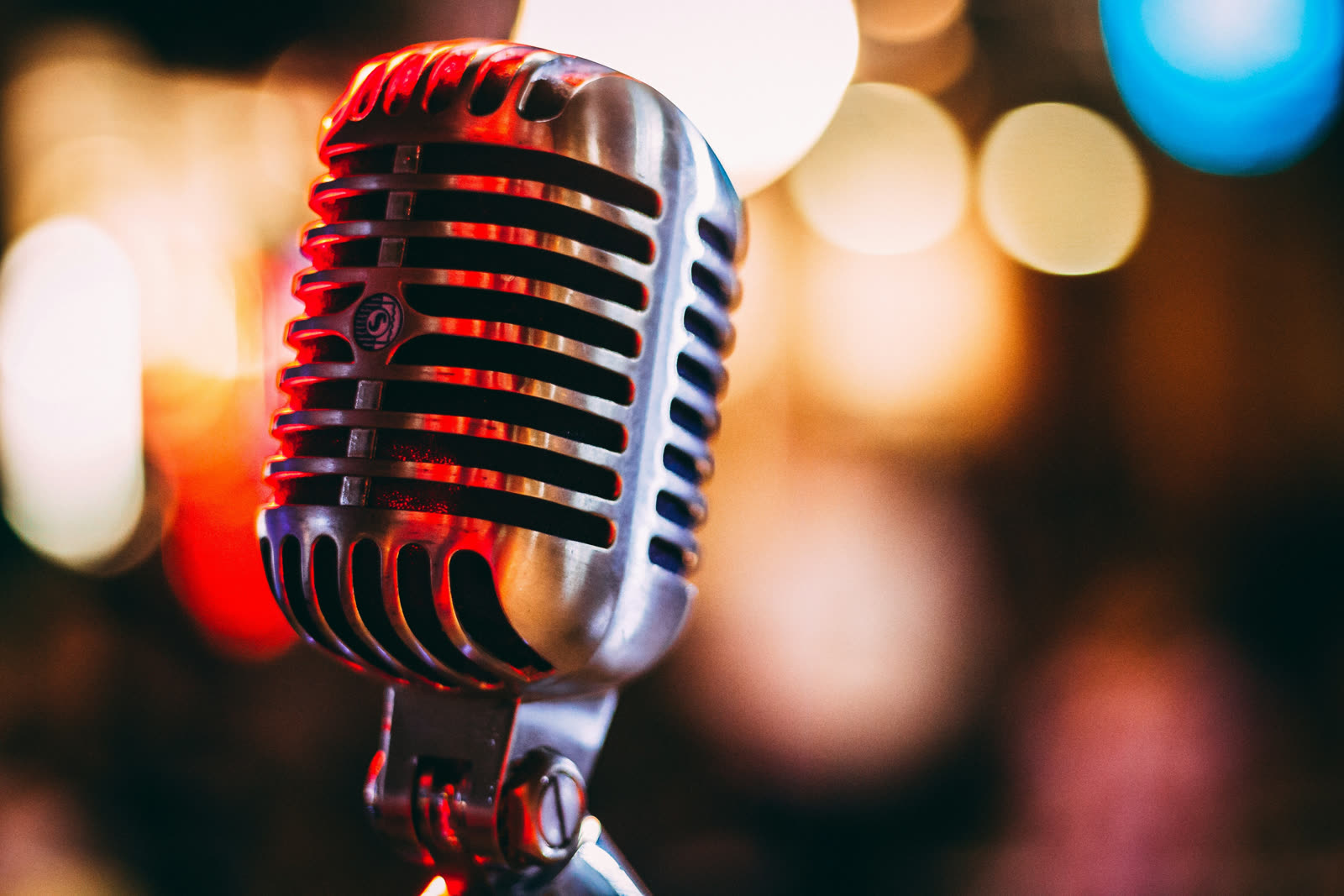A vintage microphone glowing under stage lights